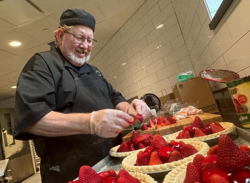 a chef prepares a series of strawberry pies for guests