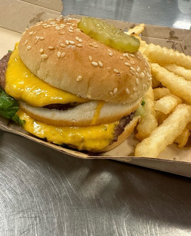 a double decker burger with a side of French fries