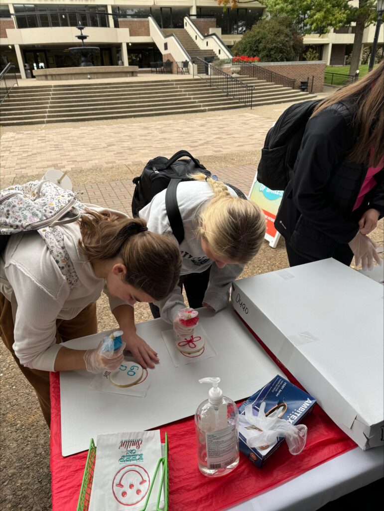 Two female students decorate cookies