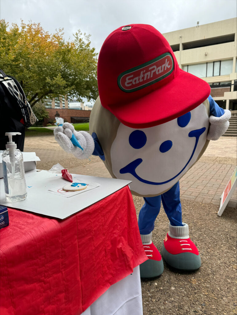 a giant cookie mascot decorates a cookie
