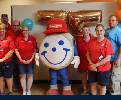a group of people stand with a life-size cookie mascot