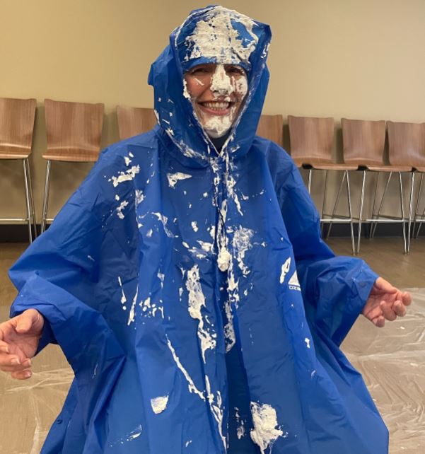 a person in a tarp with pie all over her face
