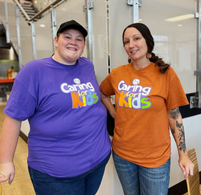 two women in caring for kids shirts
