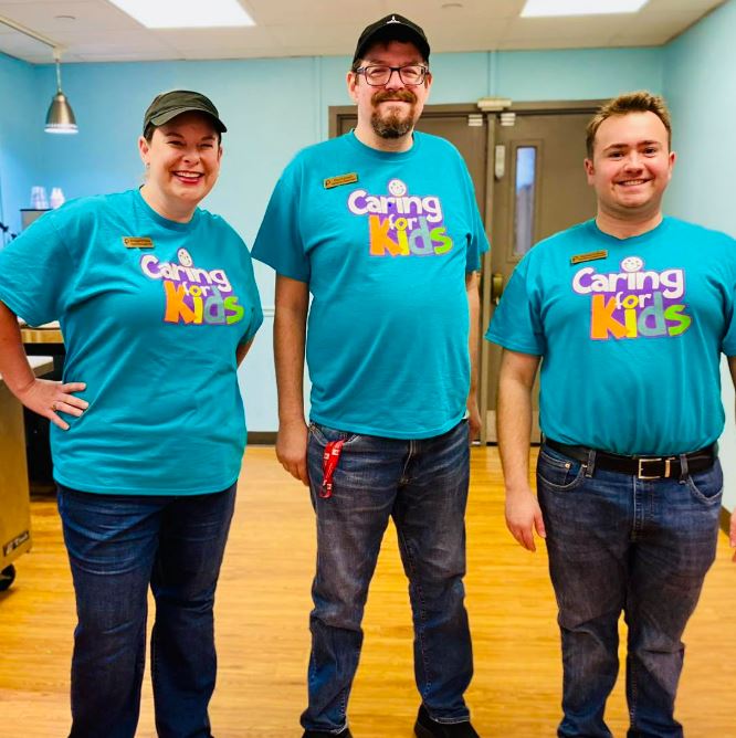 three people in Caring for Kids T-shirts