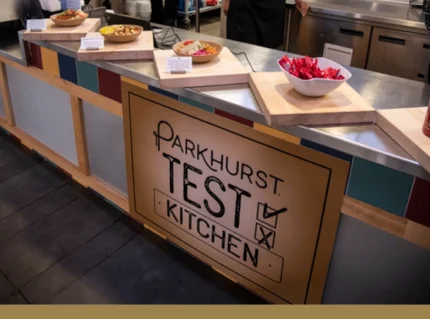 Innovation With Heart. Parkhurst Test Kitchen sign with plated food presented above.