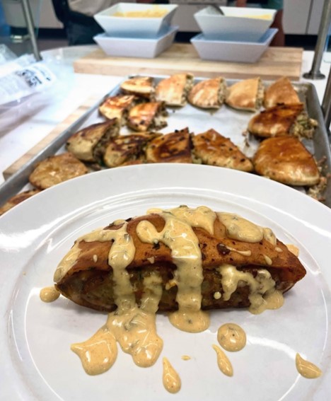 arayes on a white plate in front of a tray of arayes