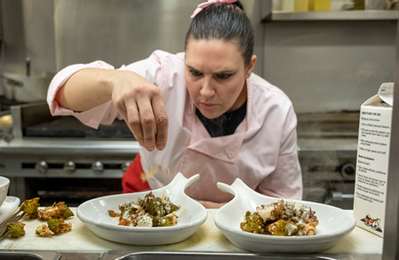 A Parkhurst chef seasoning meals during a chef engagement event for the Culinary Leadership team.
