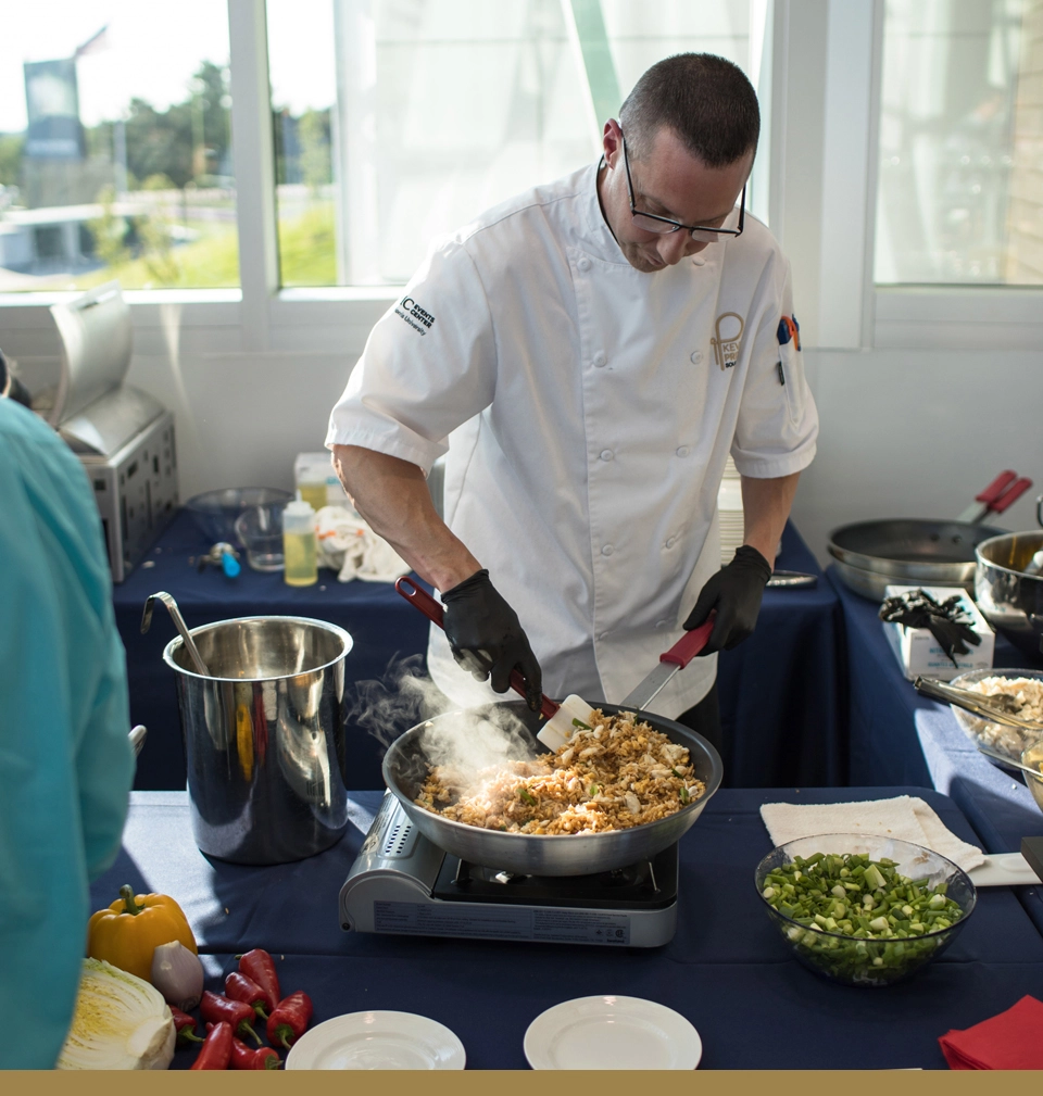 A Parkhurst chef cooks a delicious and innovative meal in a hot pan.