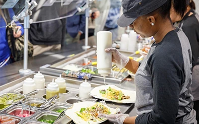 Parkhurst chef prepares nutritious salads for students in a higher education dining hall.