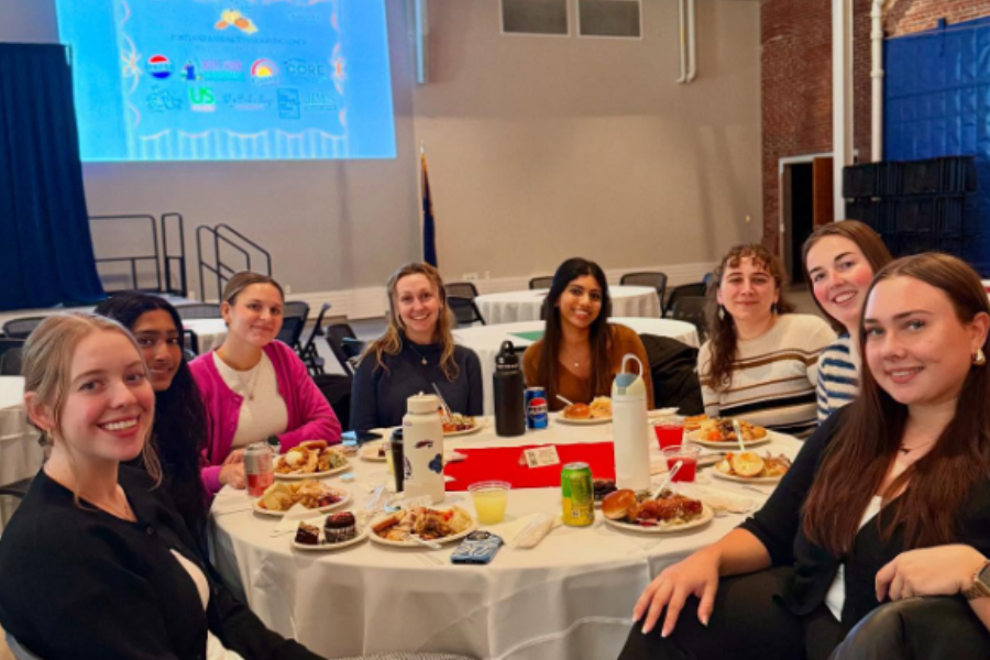 a group of women sit around a white-linen table