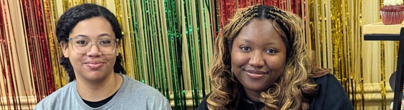 Two students sit at a table with information about Marietta College's Black History Month Dining Hall takeover