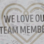 banner that says "we love our team members" with many signatures and notes from guests sharing their gratitude