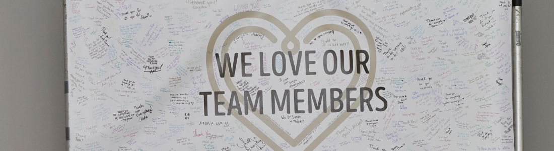 banner that says "we love our team members" with many signatures and notes from guests sharing their gratitude