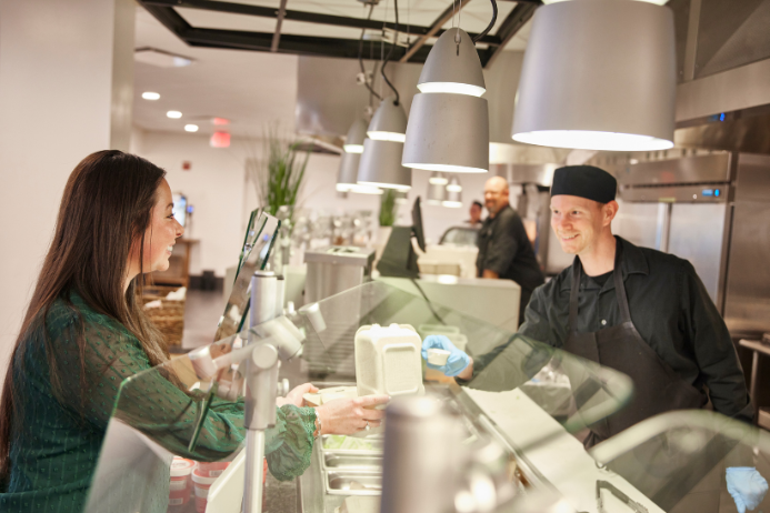 women at a corporate cafe being handed her food by a parkhurst team member