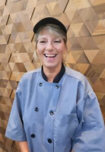 Woman standing in front of wooden wall in Parkhurst uniform