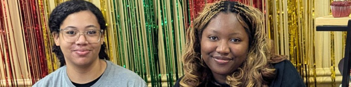 Two students sit at a table with information about Marietta College's Black History Month Dining Hall takeover