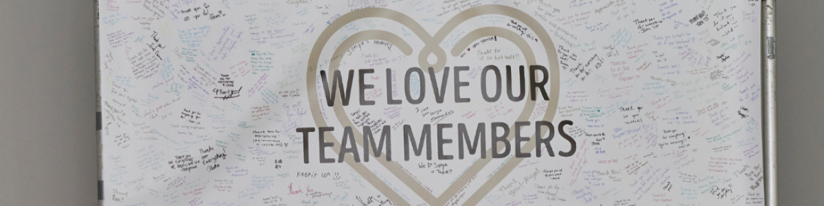 banner that says "we love our team members" with many signatures and notes from guests sharing their gratitude