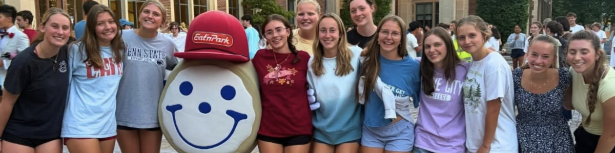 Group of Students with their arms around each other and the Eat'n Park Smiley Cookie