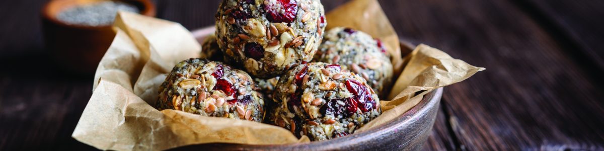 Healthy raw oatmeal balls with chia seeds, dried cranberries, grated coconut, flax seeds and honey